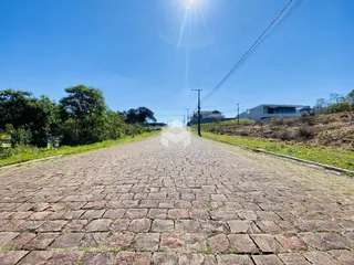 Uma estrada pavimentada se estende por uma paisagem verde sob um céu azul.