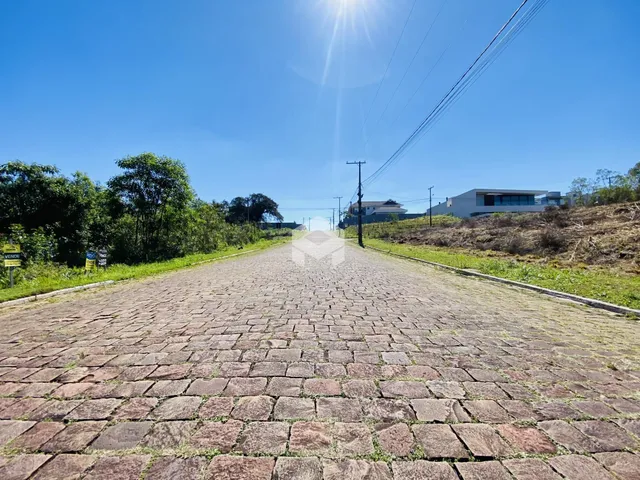 Uma estrada pavimentada se estende por uma paisagem verde sob um céu azul.