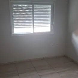 Foto de uma janela branca com venezianas em um ambiente interno.