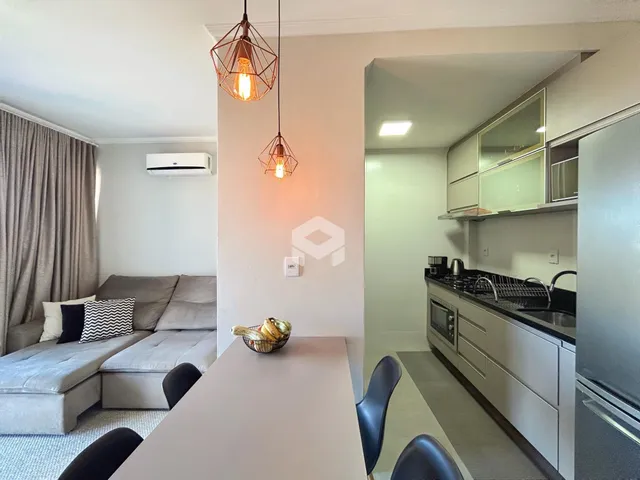 Sala de estar com sofá e mesa de jantar em um apartamento.
