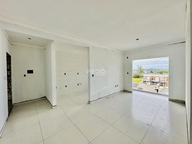 Interior de um ambiente com paredes brancas e piso de cerâmica, com abertura para o exterior.