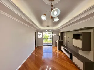 Sala de estar com piso de madeira e porta de vidro que dá acesso ao exterior.