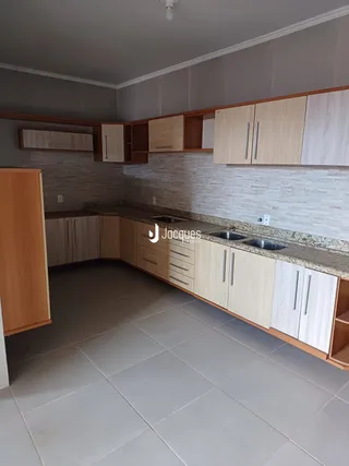 Uma cozinha com armários de madeira e piso de cerâmica.