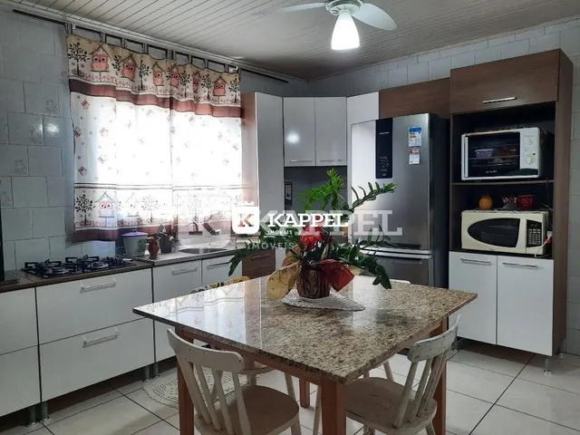 Foto de uma sala de jantar com mesa de madeira e armários brancos.