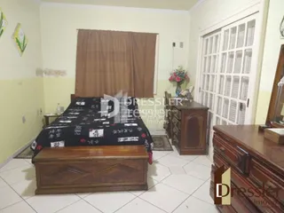 Quarto com cama e móveis de madeira no interior da propriedade.