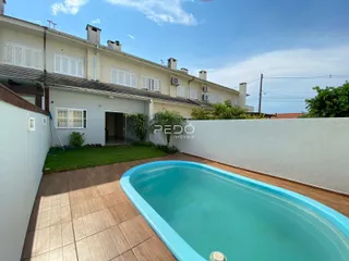 Vista externa de uma residência com piscina e jardim.