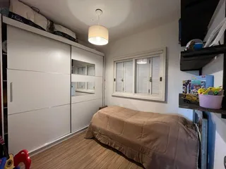 Quarto com cama e armário branco.