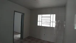 Foto de um interior com paredes brancas e uma janela.