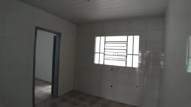 Foto de um interior com paredes brancas e uma janela.