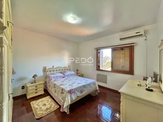 Quarto com cama e janela em ambiente interno.