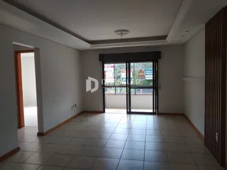 Interior de uma sala com piso de cerâmica e portas de vidro.