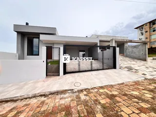 Fachada moderna de uma casa em Lajeado, Brasil, com portão de metal preto.