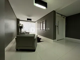 Sala de estar com piso claro e paredes cinzas em um imóvel no Brasil.