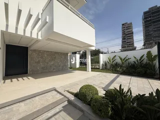 Fachada moderna de uma residência com área externa pavimentada.