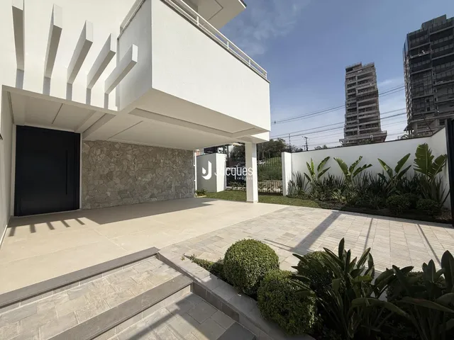 Fachada moderna de uma residência com área externa pavimentada.