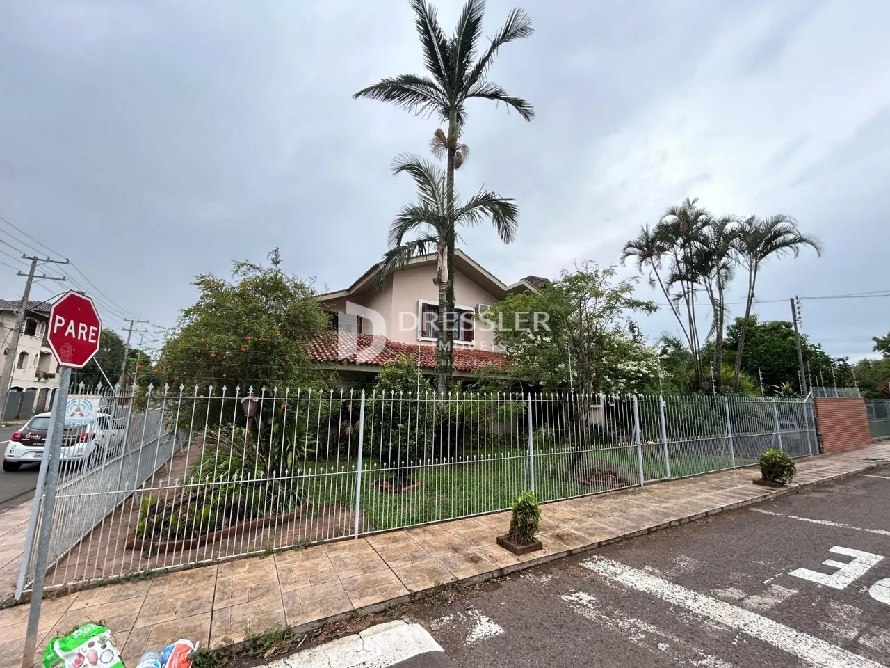Vista da fachada de uma residência em Lajeado, Brasil com cerca e vegetação.
