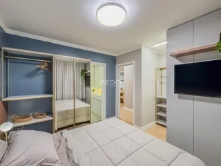 Quarto com armários embutidos e piso de madeira clara.