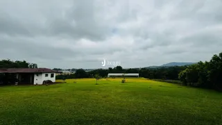 Paisagem de um campo verde com estruturas ao fundo em Lajeado, Brasil.