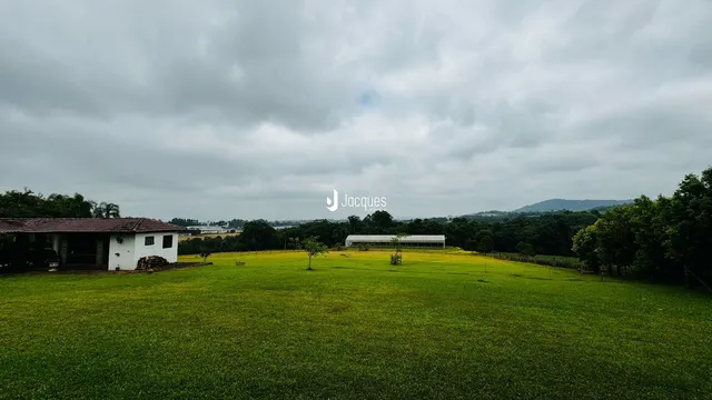Paisagem de um campo verde com estruturas ao fundo em Lajeado, Brasil.
