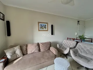 Sala de estar com sofá e poltronas em um imóvel no Brasil.