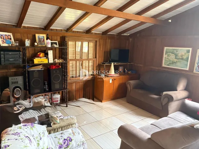 Sala de estar com revestimento de madeira e piso cerâmico.
