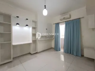 Sala de estar com paredes brancas e piso de cerâmica.