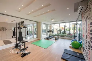 Sala ampla com piso de madeira e equipamentos de ginástica.
