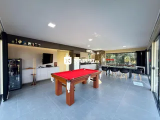 Sala ampla com mesa de bilhar e vista para o exterior.