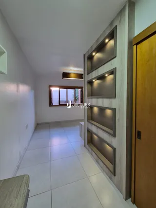 Hall de entrada com paredes brancas e piso de cerâmica claro.