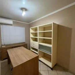 Prateleiras de madeira em um ambiente interno com acabamento neutro.