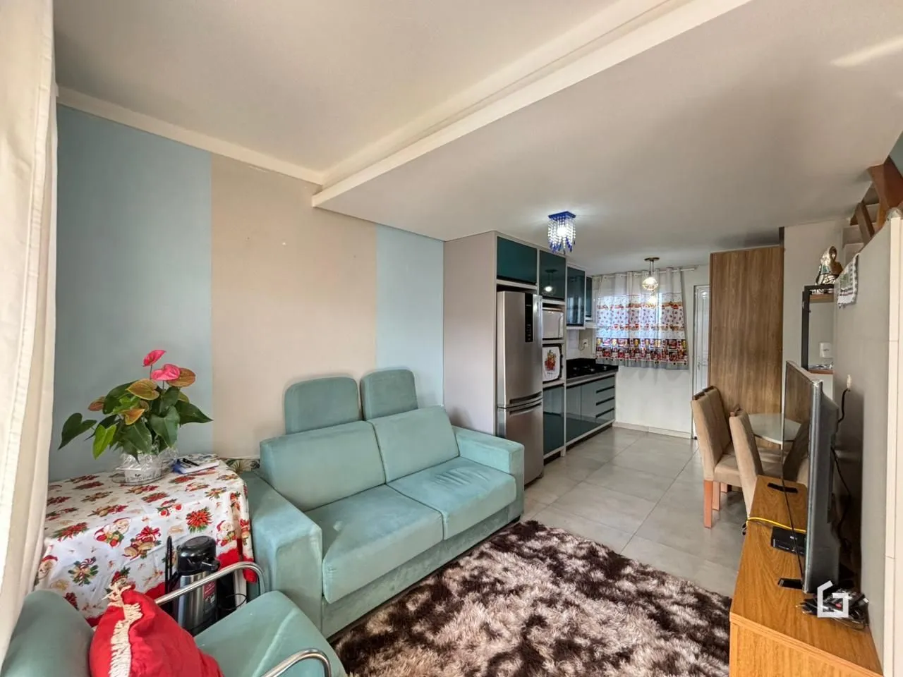 Foto de uma sala de estar com sofá azul e tapete marrom.