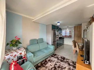 Foto de uma sala de estar com sofá azul e tapete marrom.