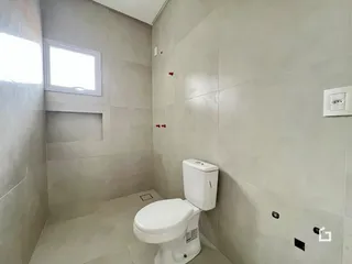 Foto de um banheiro com paredes revestidas de cerâmica e uma janela.