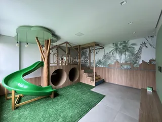 Interior de uma sala com piso verde e elementos de madeira em Lajeado, Brasil.