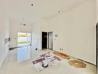 Ambiente interno amplo e vazio com piso de concreto em reforma.