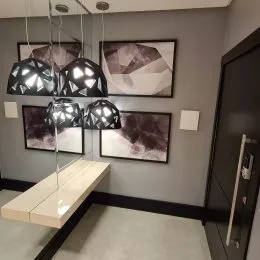 Foto de um interior com paredes cinzas e quadros na parede.