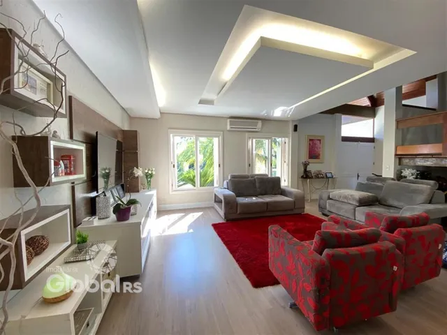 Sala de estar moderna com piso de madeira e sofá vermelho.