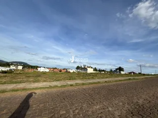 Vista externa de uma propriedade com paisagem de colinas ao fundo.