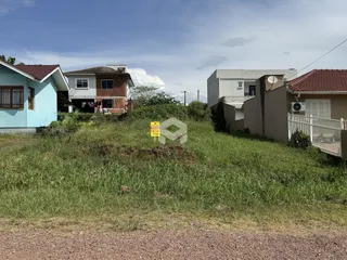 Vista externa de casas em Lajeado, Brasil, com vegetação alta na frente.