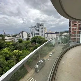 Vista panorâmica de uma área urbana com vegetação e edifícios ao fundo.