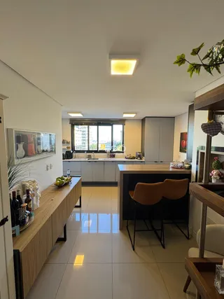 Vista de uma sala de estar com cozinha moderna em um apartamento.