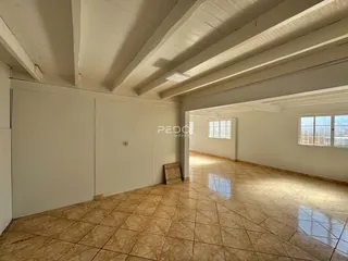 Hall de corredor com piso de cerâmica e forro de madeira exposta.