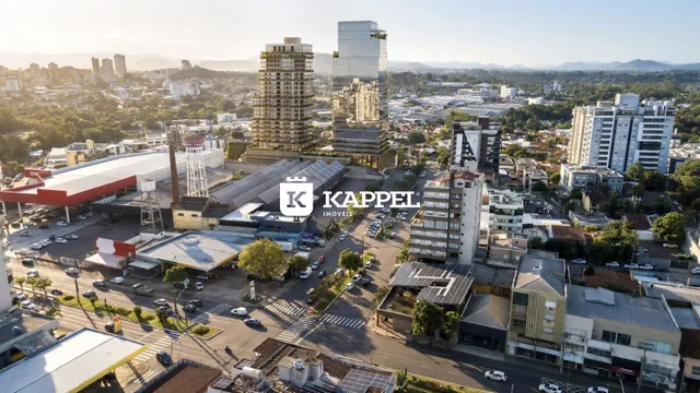 Vista aérea de um bairro urbano em Lajeado, Brasil, mostrando edifícios residenciais e comerciais.