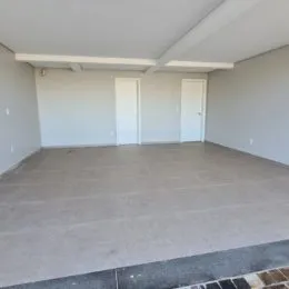 Foto de um ambiente interno vazio com paredes brancas e portas.