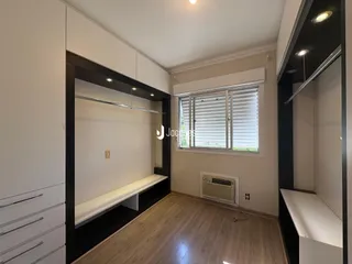 Foto de uma sala de estar com piso de madeira e grandes janelas.