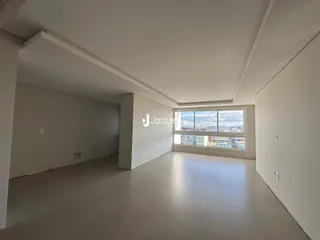 Ambiente interno de uma sala ampla com vista para a paisagem urbana.