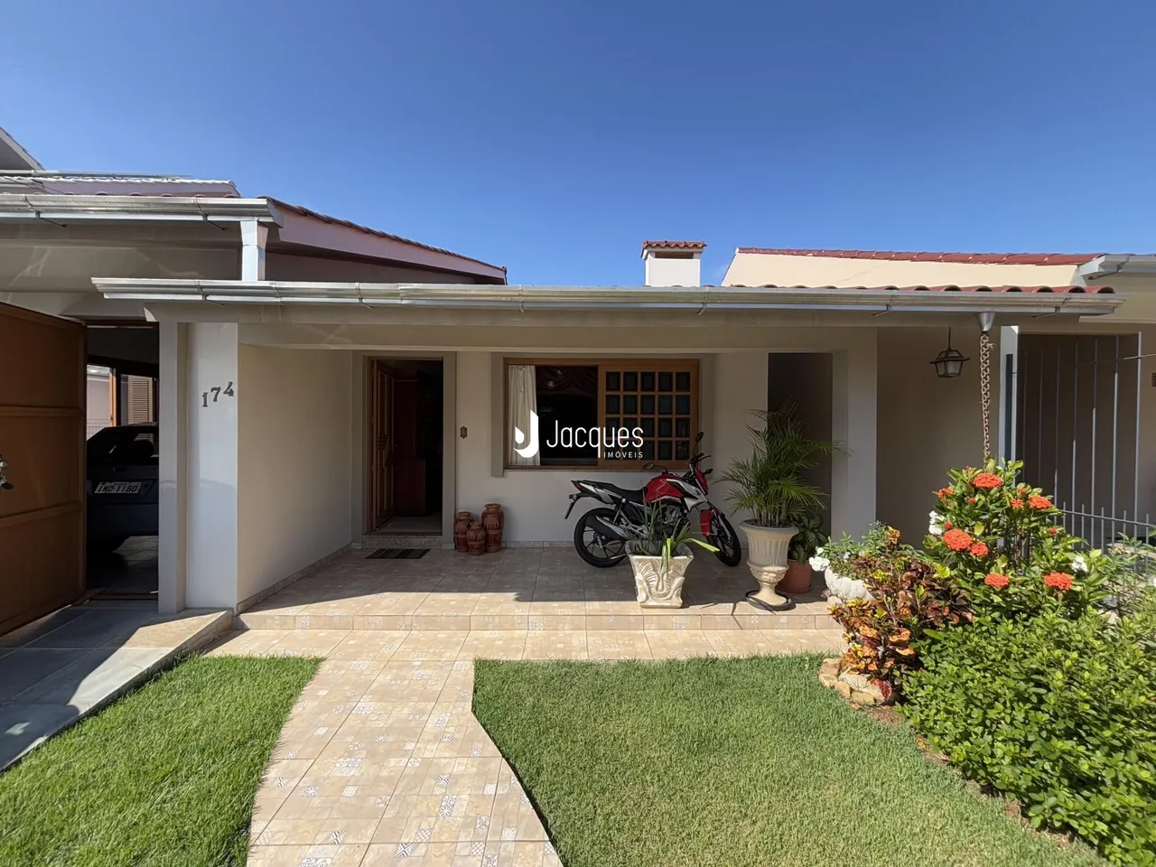 Fachada de uma residência em Lajeado, Brasil com jardim e calçada.