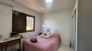 Quarto com cama e janela de madeira.