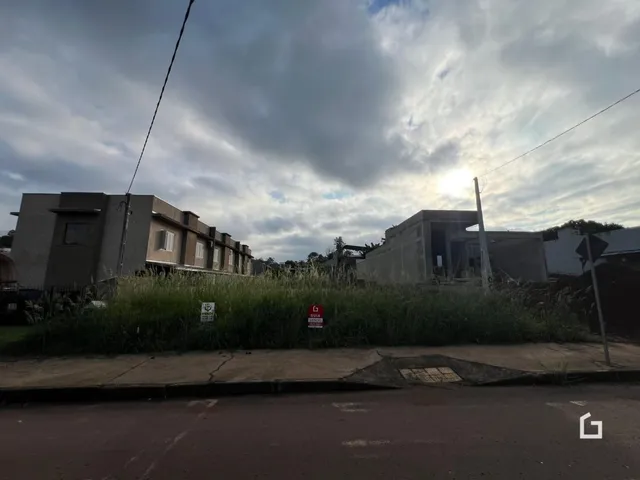 Fachada de edifícios em Lajeado, Brasil, com vegetação em primeiro plano.