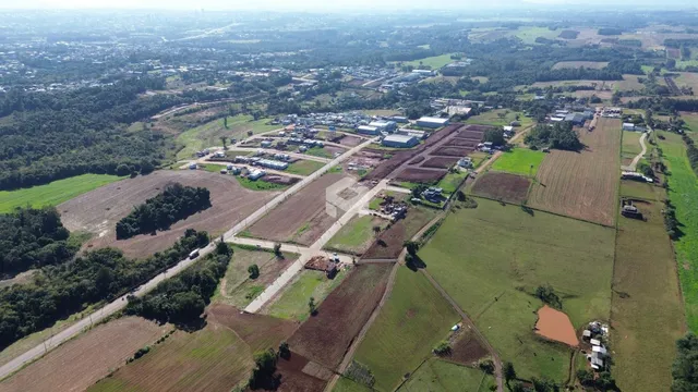 Vista aérea de uma área rural com campos e vegetação no Brasil.